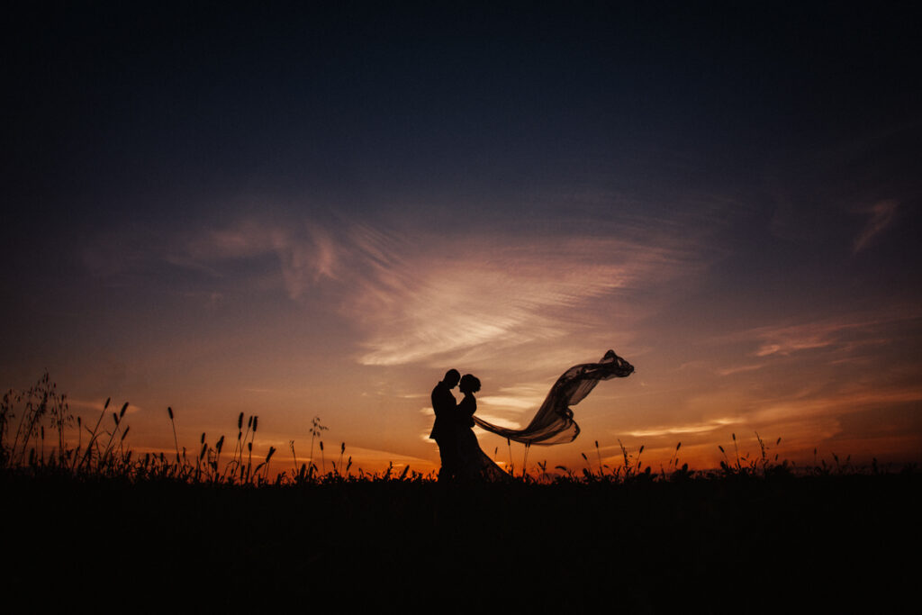Image of a bride and groom in silhouette against a Manitoba sunset captured by Winnipeg Wedding photographer Michael Scorr.