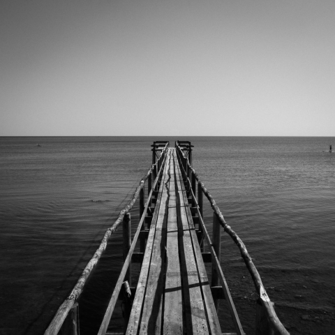 Black and white image on top of a baordwalk out into the lake in Matlock, Manitoba