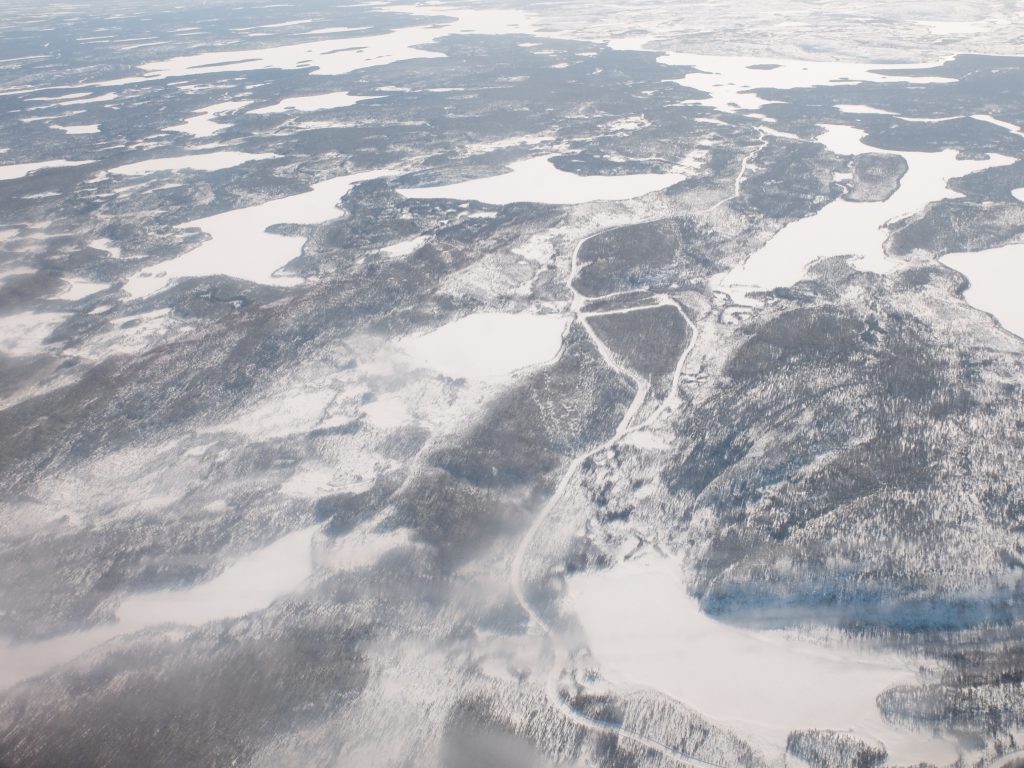 Aerial view from a plane overlooking a white winter covered landscape in Manitoba, Canada.