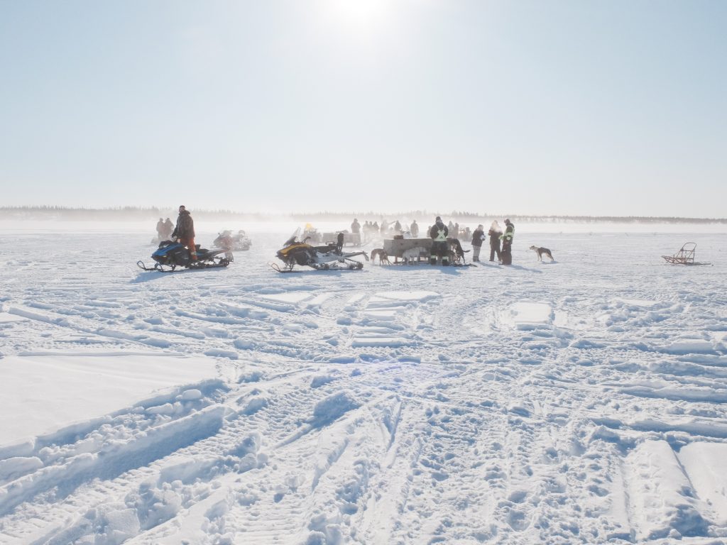 Image of sleigh dogs getting ready to race in the town of Lac Brochet northern Manitoba. Winnipeg Wedding Photographer Michael Scorr captures this image on a Fujifilm x30 and processed in camera with a Classic Kodak Chrome recipe.