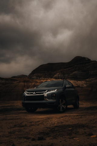 Dark and moody shot of a Mitsubishi with LED lights on set against a backdrop of Hoodoo's Trail.