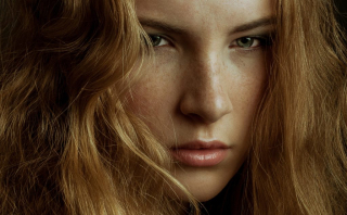 Close up shot from a fashion photoshoot with a model from Swish Model Management. Hair covers most of the models freckled face.